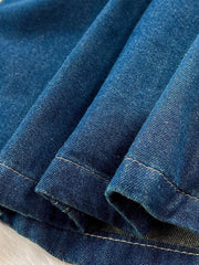 Denim overall detail with visible stitching and distressed texture.
