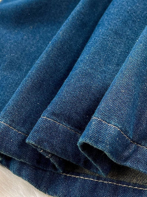 Denim overall detail with visible stitching and distressed texture.