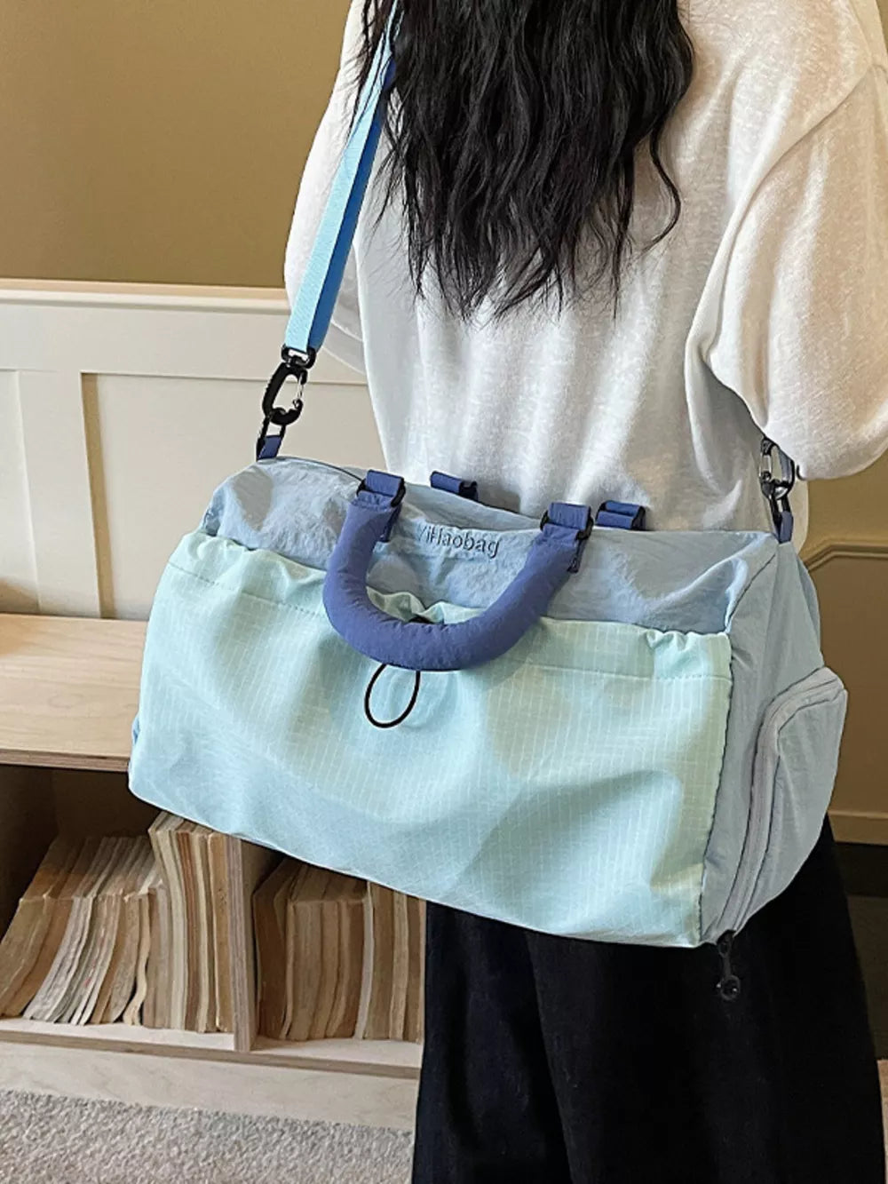 Light blue Oxford cloth travel bag with blue handles and strap, dual-tone design.