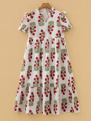 V-neck mini dress with pockets in white with red floral print, short sleeves, and tiered skirt.