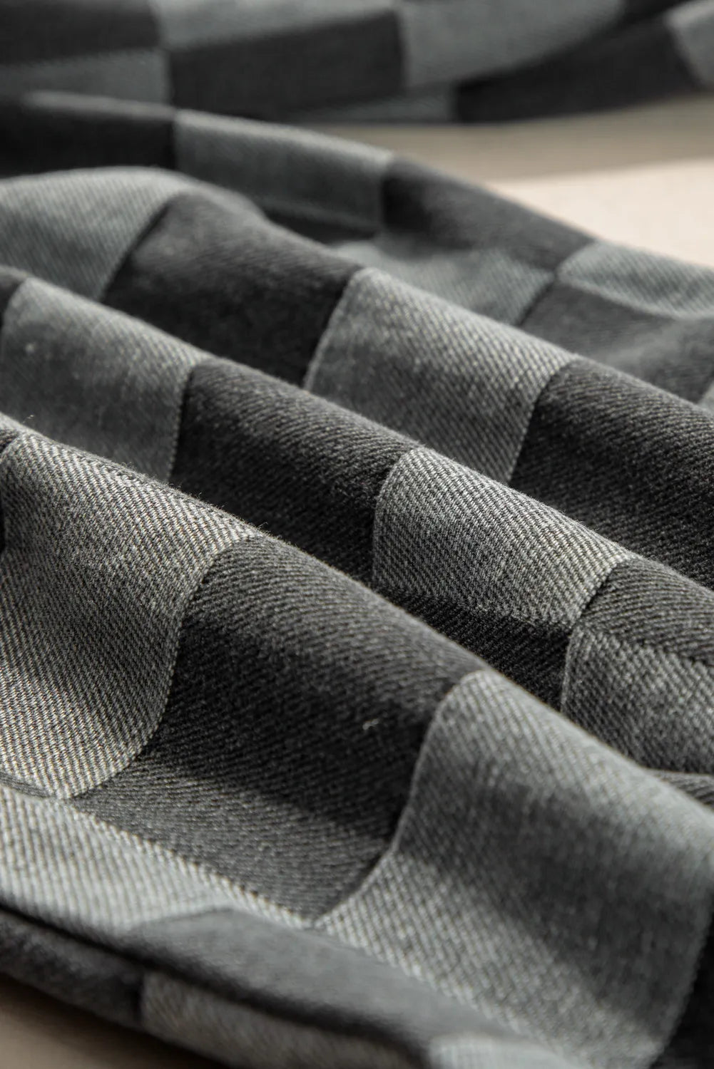 Checkerboard denim wide leg trousers in dark gray with a textured weave.