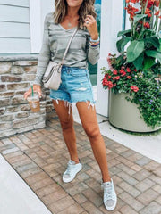 Sage camo v-neck long sleeve t-shirt with pocket, styled with denim shorts.