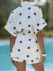 Chic white polka dot tie-waist two-piece set with cuffed short sleeves and shorts.