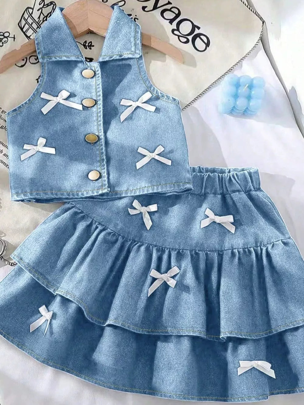 Light blue denim halter vest and tiered skirt set with white bow accents.