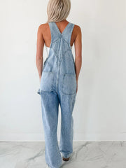 Light wash denim overalls with wide straps, relaxed fit, and back pockets.