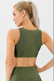 Green sports bra with mesh back panels and racerback detail.