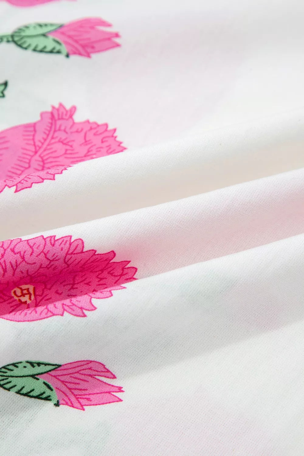 White cotton blouse with vibrant pink floral print and green leaves