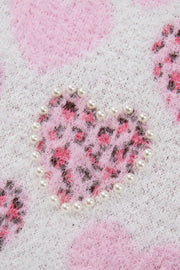 Fuzzy knit sweater in blush pink with a pearl-embellished heart jacquard pattern.
