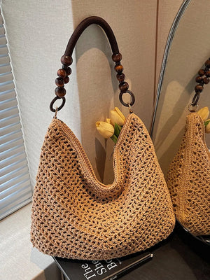 Khaki textured knit shoulder bag with wooden bead handle and dark brown strap.