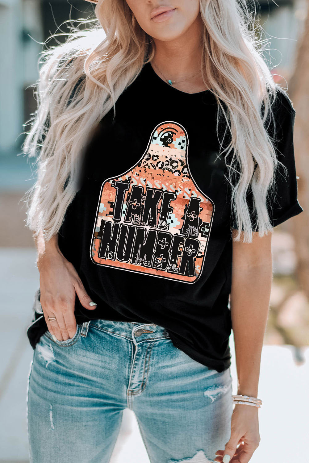 Black graphic t-shirt with "Take A Number" text on a tag design with leopard and camouflage print.