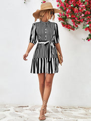 Black and white striped shirred waist dress with tie belt and short sleeves.