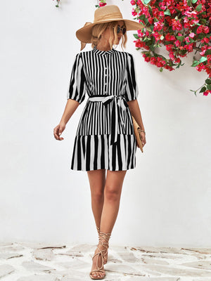 Black and white striped shirred waist dress with tie belt and short sleeves.