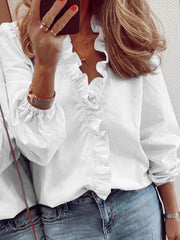 White blouse with cascading ruffle front and balloon sleeves.