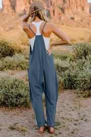 French blue cotton wide-leg jumpsuit with pockets and adjustable straps, worn with a white tank.