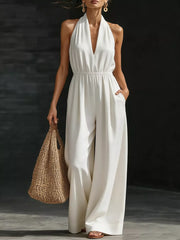 White halter jumpsuit with wide legs and elastic waist, featuring pockets.