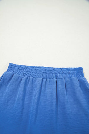 Blue flowing shorts with elastic drawstring waist and textured fabric detail.