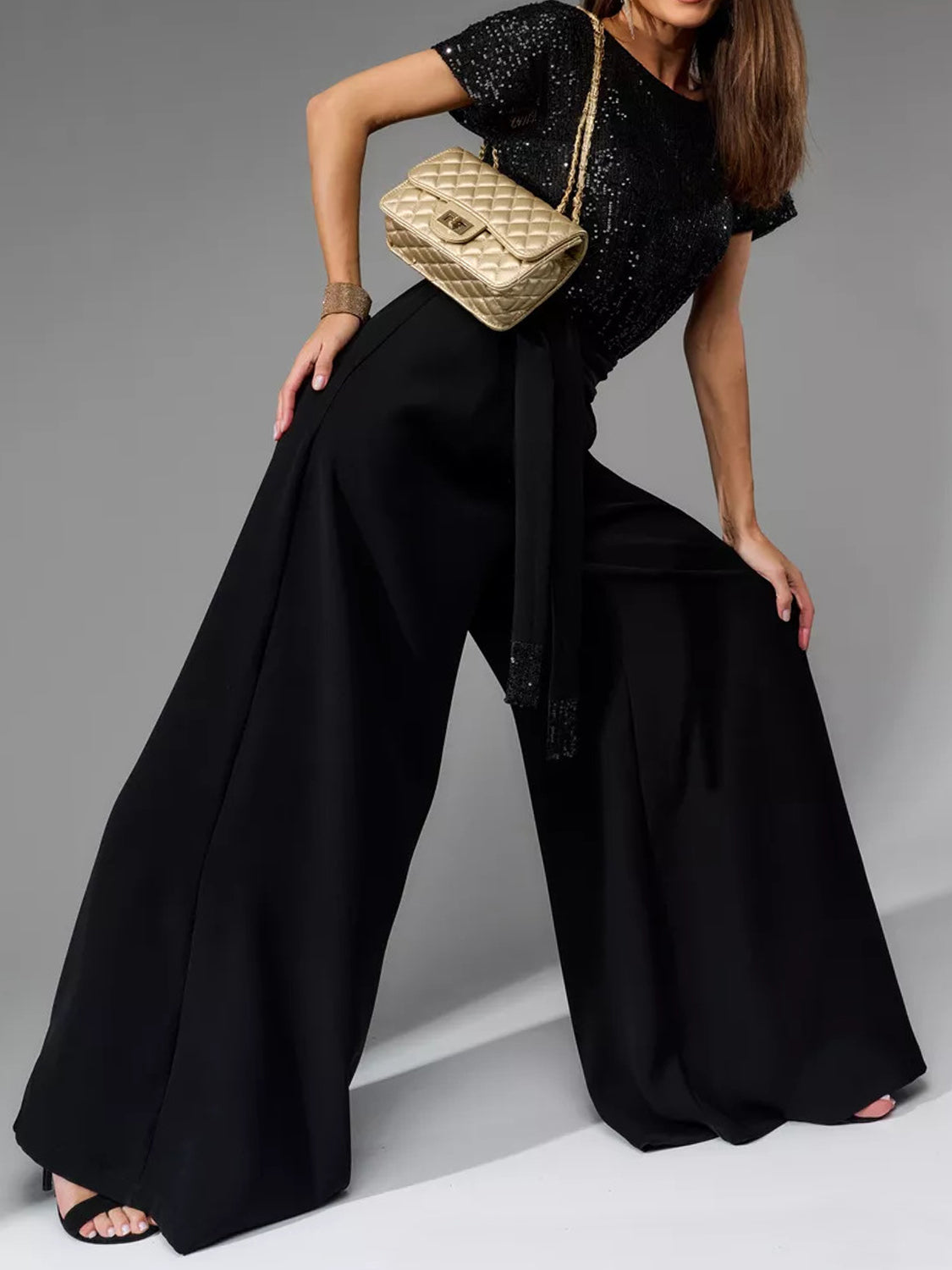 Black sequin bodice and palazzo pant suit with a belted waist and beaded trim.