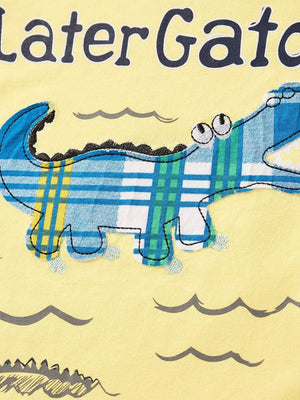 Yellow cotton tee with a playful blue and green plaid alligator graphic and wavy water print.