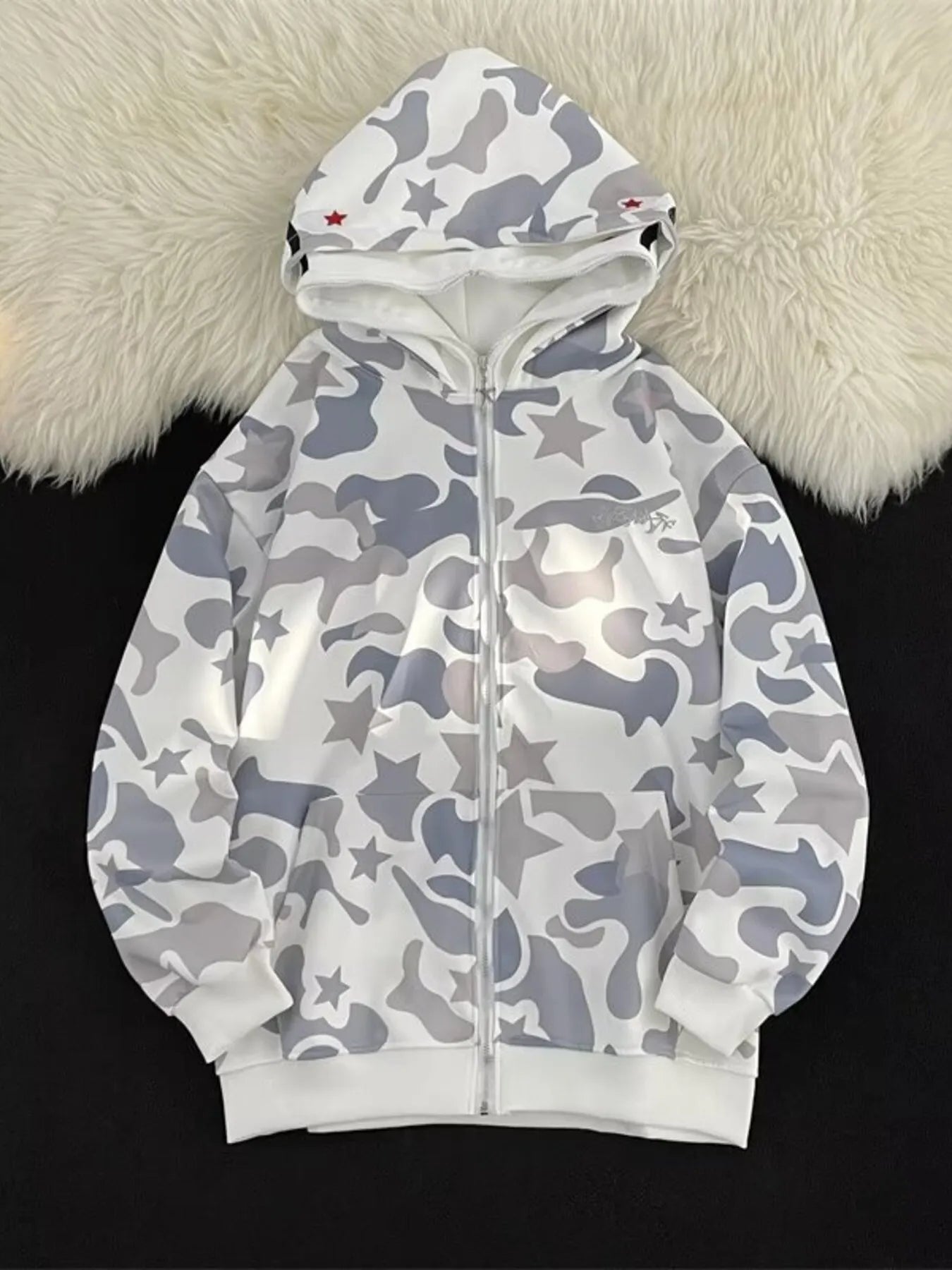 Off-white camo print zip-up hoodie with stars and red accents on the hood.