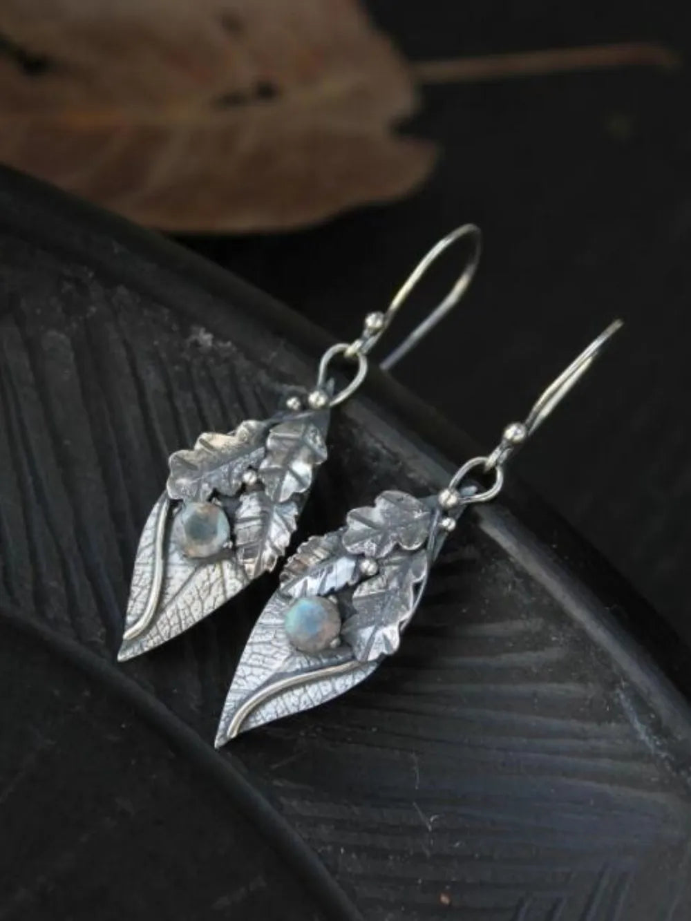 Textured leaf drop earrings with moonstone accents and silver alloy hooks.