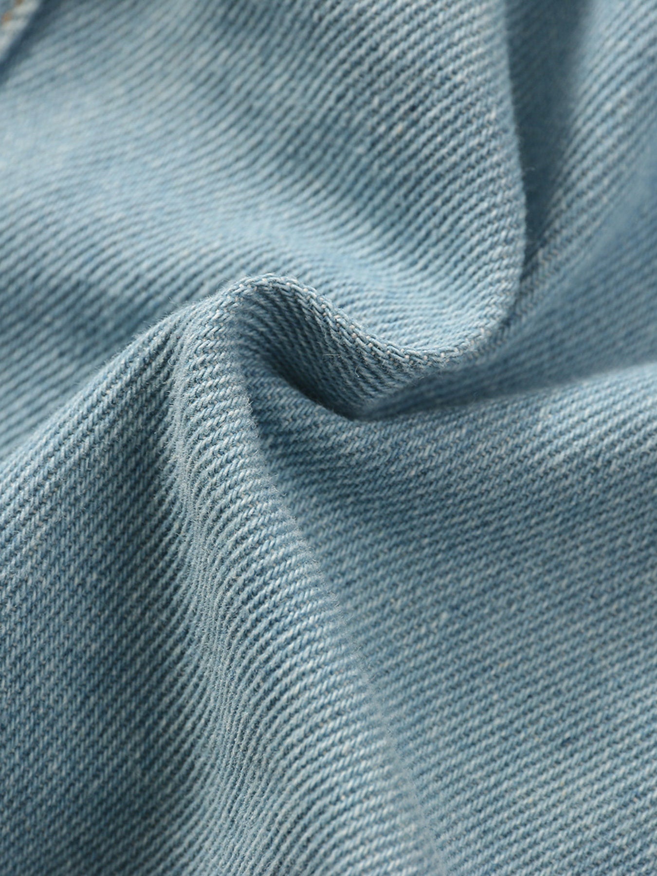 Light blue distressed denim skirt fabric detail