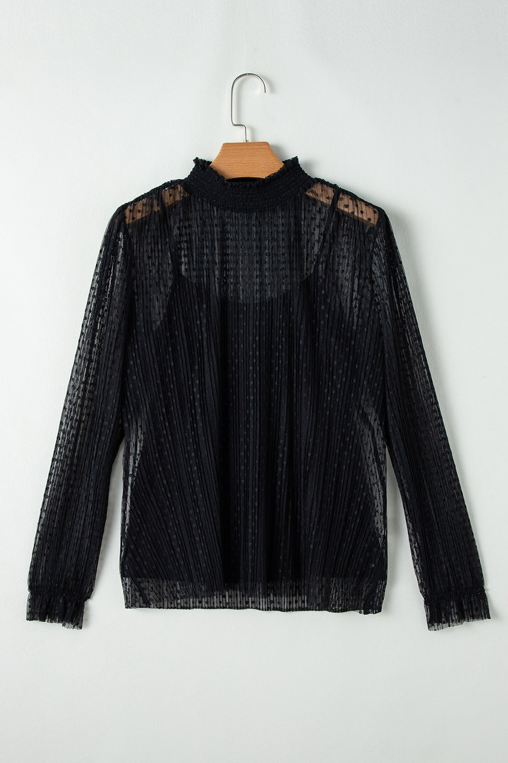 Black sheer mock neck blouse with textured dots and vertical pleats.