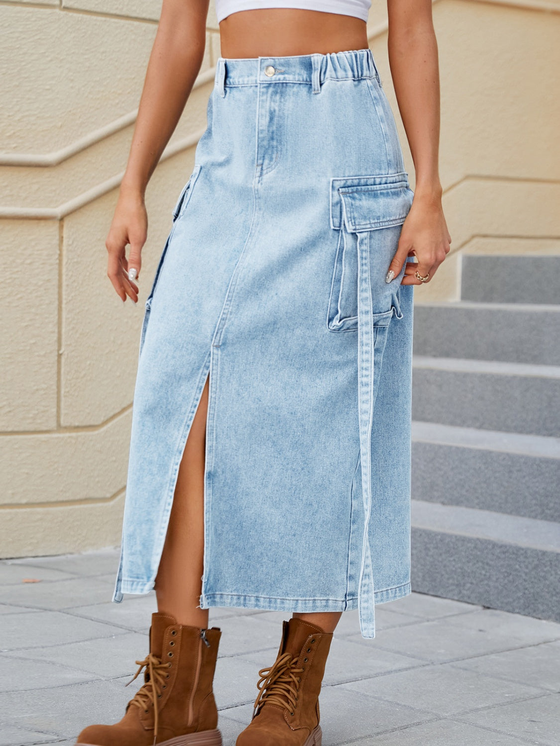 Light blue denim midi skirt with high rise, slit, and cargo pockets.