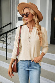 Cream textured henley blouse with button detail and long sleeves.