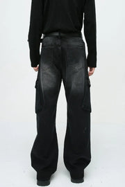 Baggy black denim cargo pants with zipper pockets and a faded wash.