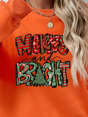 Orange crewneck sweatshirt with Merry and Bright graphic and Christmas tree detail