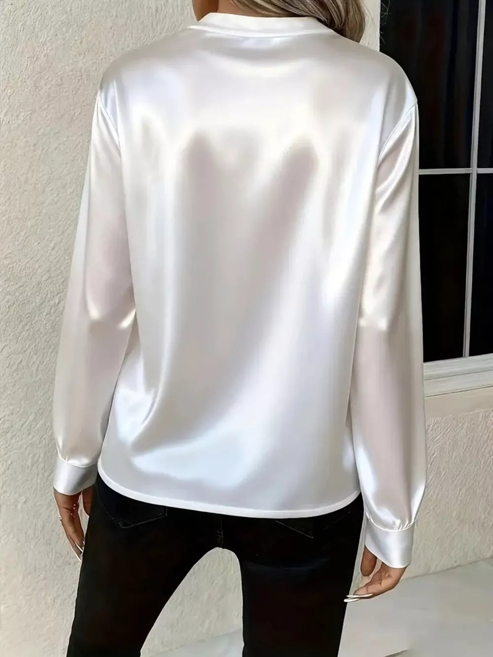 White satin maternity blouse with long sleeves and buttoned cuffs.