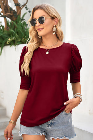 Burgundy crew neck top with puffed short sleeves and cuff detail