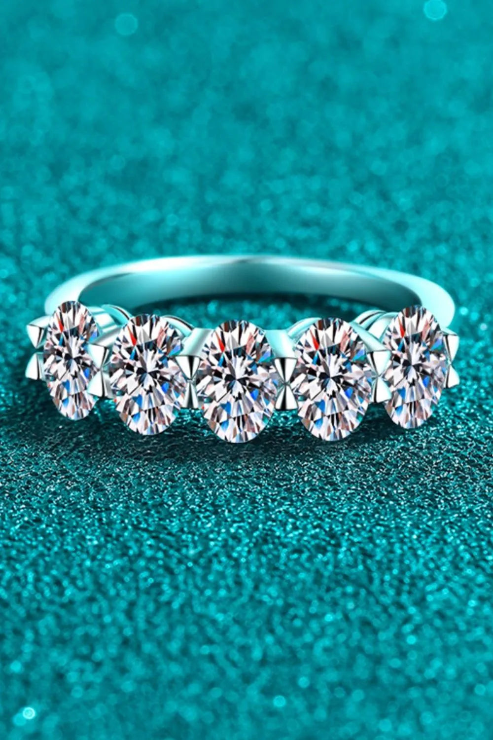 Silver band ring with five oval moissanite stones in a celestial cluster setting.