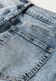 Cuffed hem washed denim trousers in medium acid wash with visible stitching details.