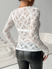 White scalloped lace bodysuit with long sleeves and floral pattern.