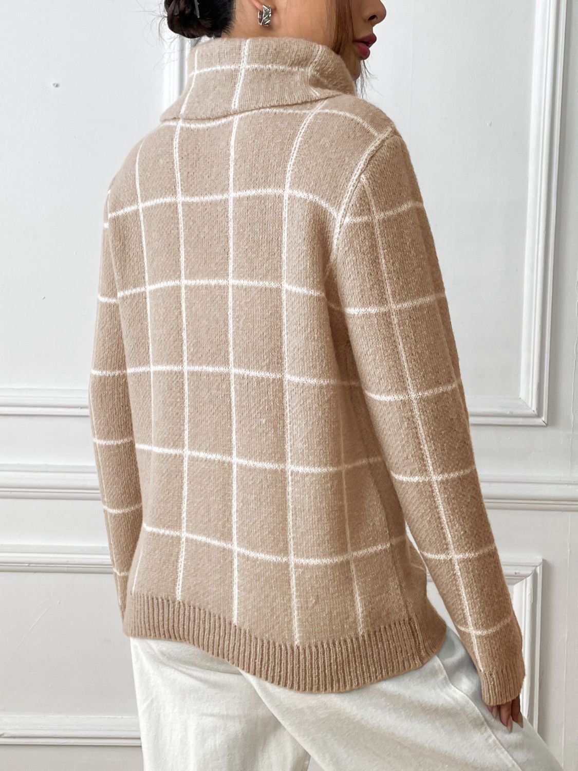 Tan grid-patterned turtleneck knit sweater with ribbed hem and cuffs.