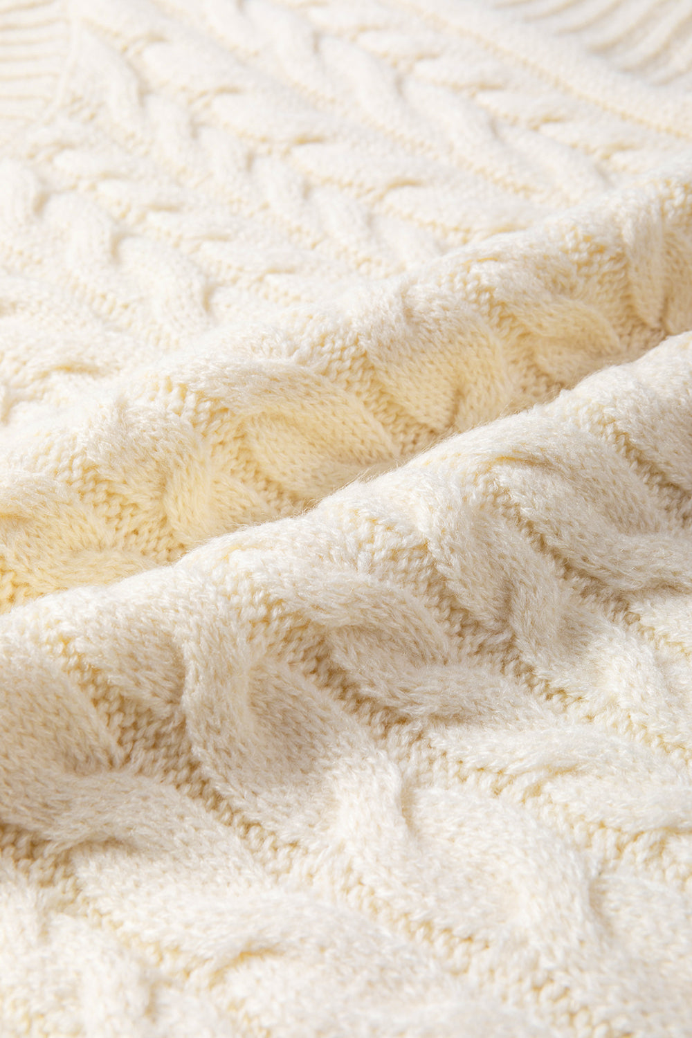 Ivory cable knit mock neck vest with chunky texture.