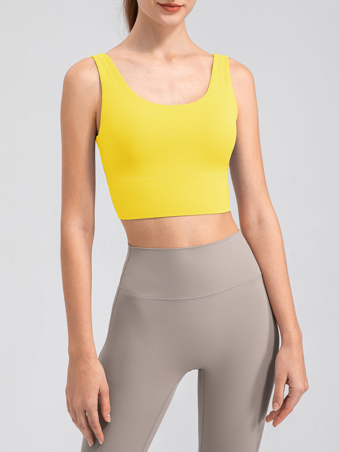 Yellow performance crop top with scoop neck and ribbed band, paired with grey leggings
