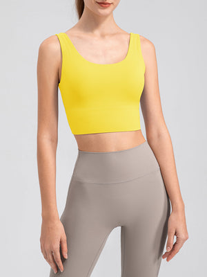 Yellow performance crop top with scoop neck and ribbed band, paired with grey leggings