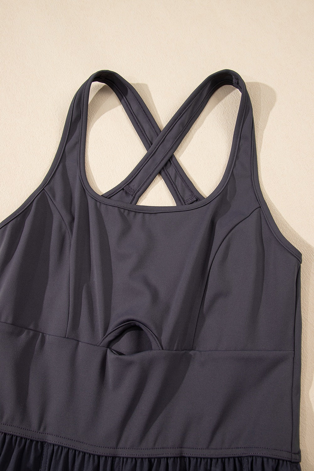 Dark gray jumpsuit with cutout bodice, crisscross straps, and gathered legs.