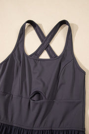 Dark gray jumpsuit with cutout bodice, crisscross straps, and gathered legs.