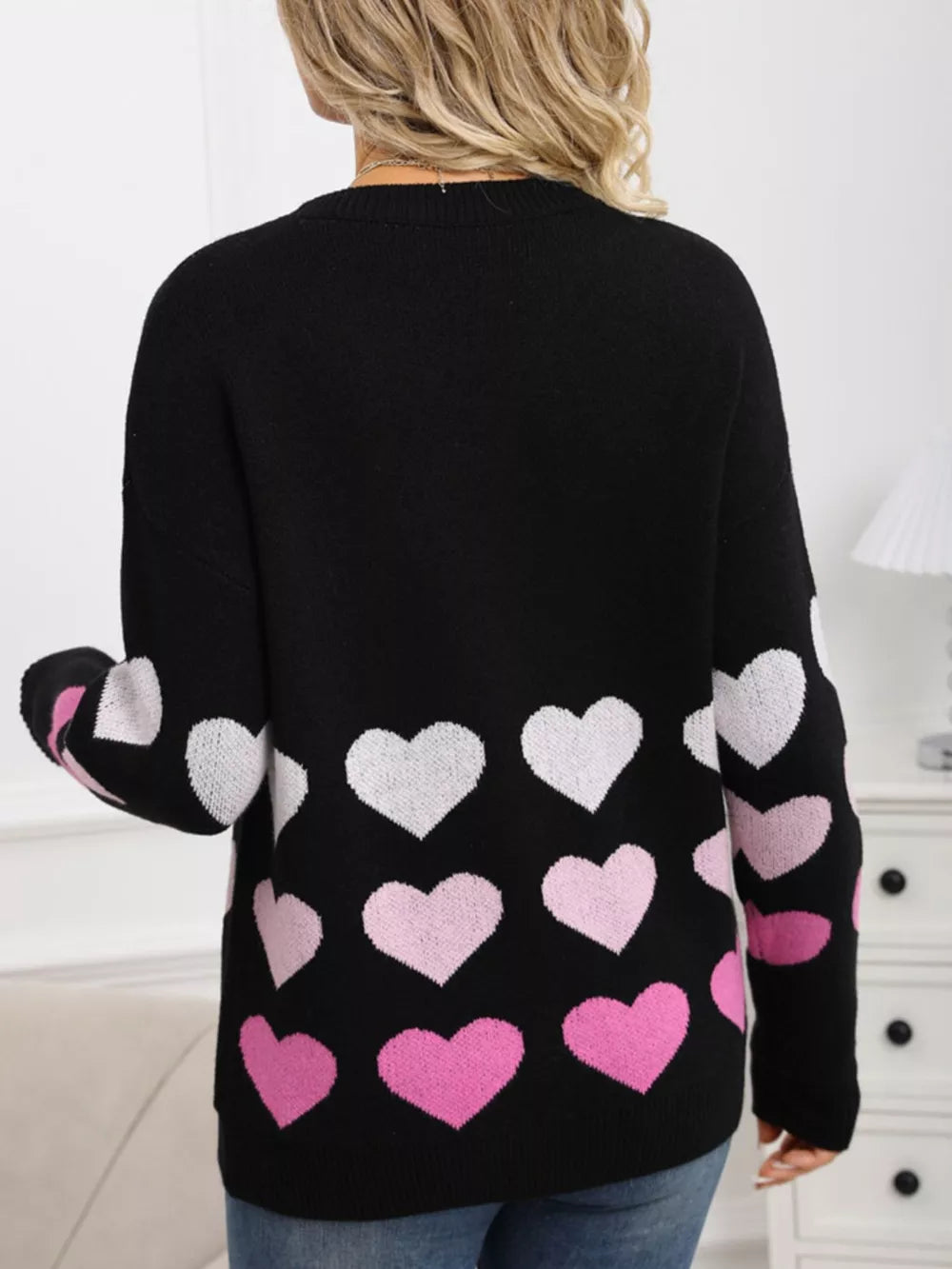 Black crew neck sweater with allover pink and white heart print.