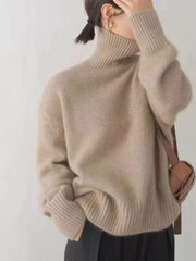 Beige acrylic turtleneck sweater with dropped shoulders and ribbed cuffs and hem.