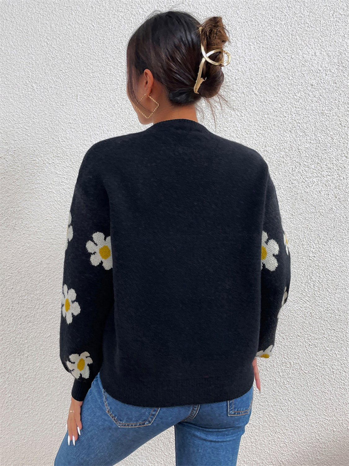 Black knit sweater with puff sleeves and white daisy pattern