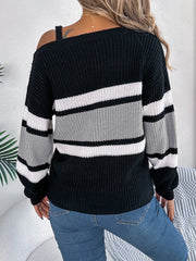 Asymmetric stripe knit sweater with one shoulder strap detail, black, white, and gray stripes.