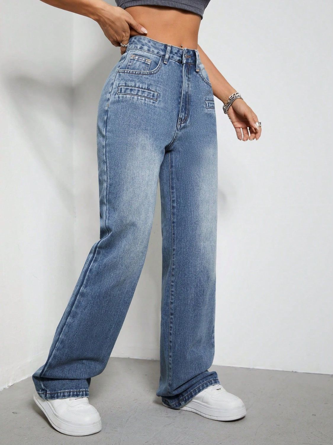 Medium wash cotton jeans with wide legs and utility pockets.