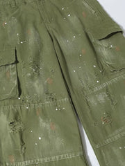 Green distressed cargo pants with paint splatter accents and ripped details.