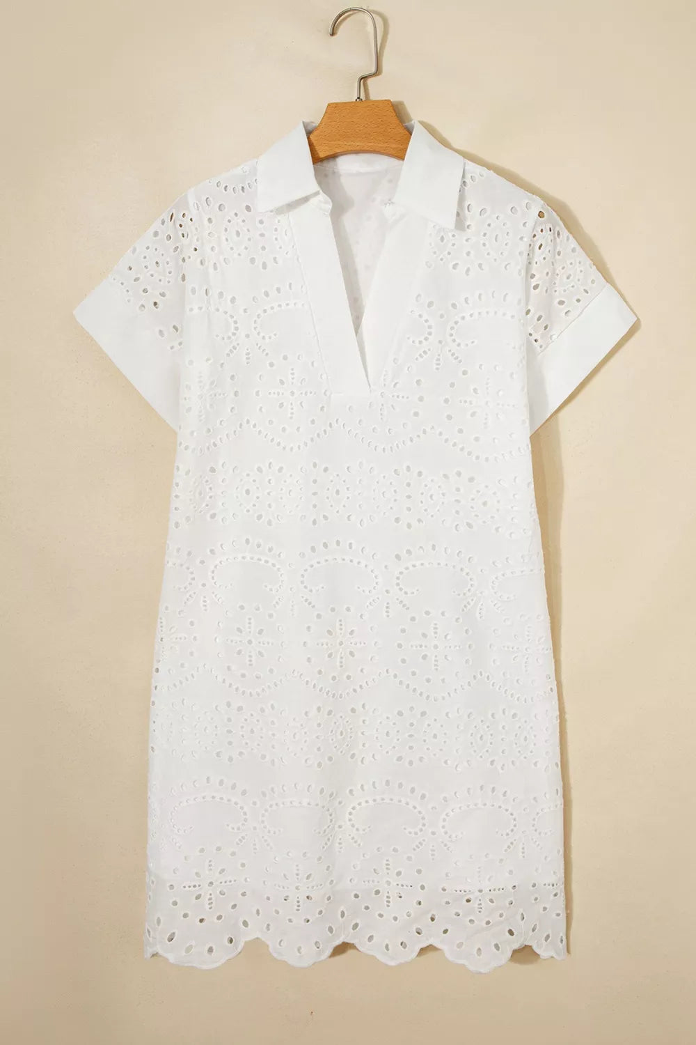 White cotton eyelet mini dress with short sleeves and a V-neck collar.