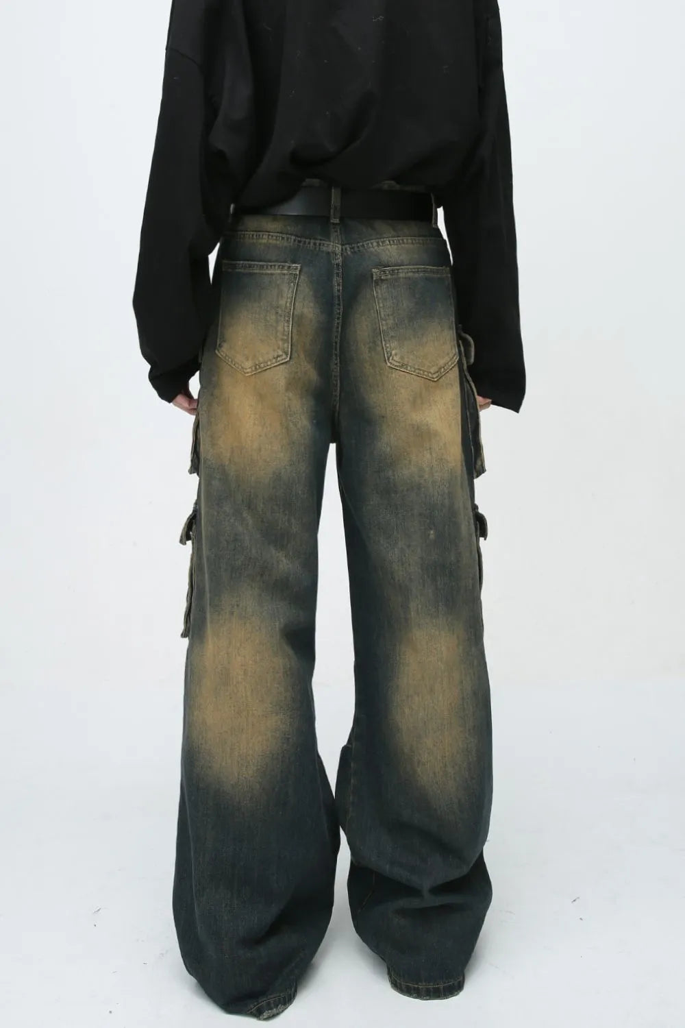 Faded wash dark denim oversized cargo jeans with button flap pockets and baggy fit.