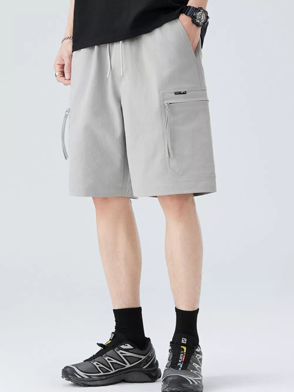 Light gray men's cargo shorts with zip pockets and drawstring waist.
